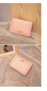 Detailed close-up of pink and beige textured crossbody bag with golden twist lock
