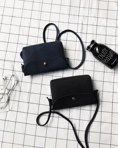Detail of mini crossbody bags featuring lychee grain texture and gold snap button closures