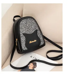 Close-up of mini backpack with sequined cat ears and gold hardware on a sofa