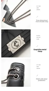 Détail du sac à bandoulière en cuir noir matelassé avec chaîne gris foncé et fermoir rotatif