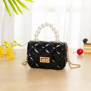 Mini black quilted jelly bag with elegant white pearl handle and gold chain strap
