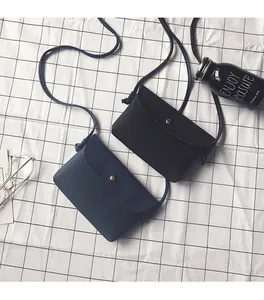 Close-up of litchi pattern PU leather crossbody bags in black and navy blue with gold buttons