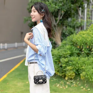 Mini black jelly bag with pearl handle, quilted texture, and gold chain strap for women