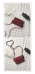 Detail view of red lychee textured mini crossbody bag with golden buckle and leather strap
