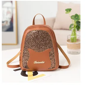 Detail of mini brown leather backpack featuring gold sequins and cat ear design decoration