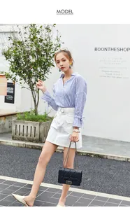 Détail d'un sac à bandoulière matelassé noir chic avec chemise rayée et jupe en jean