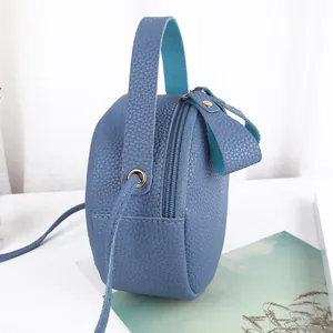 Blaue runde Mini-Umhängetasche mit Lychee-Maserung, Tragegriff und goldenen Metallteilen
