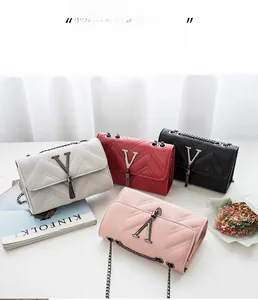 Detail of four PVC crossbody bags with V-quilted texture, metal logos and tassels