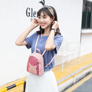 Pink sequin mini backpack with cat ear design for women shown on a model outdoors