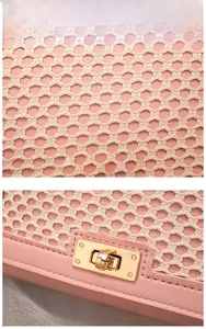 Detail of pink leather bag with beige woven mesh overlay and gold-toned twist lock