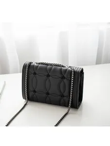 Détail du sac à bandoulière en cuir noir avec broderie circulaire et chaîne métallique