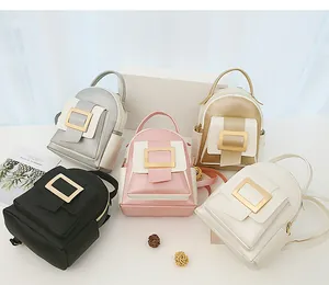 Five assorted mini backpacks in metallic and matte finishes with large square gold buckles