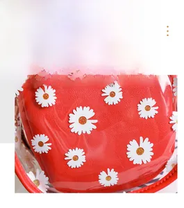 Détail du cuir rouge à texture litchi et PVC transparent avec motif marguerites blanches