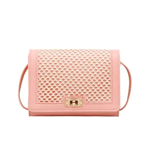 Pink crossbody bag with cream lattice weave detail and golden square rotating lock
