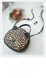 Macro view of leopard print cat-shaped bag with ear details and leather strap