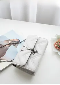 Detail of cream crossbody bag with V-quilted texture, metal logo and chain strap