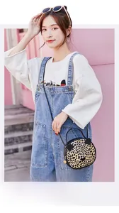 Close-up of leopard print cat-shaped crossbody bag with 3D ears on a bright pink wall