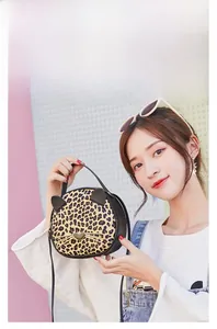 Detail of leopard print cat face crossbody bag with 3D ears and gold whiskers