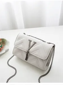 Macro detail of V-quilted faux leather crossbody bag with metal tassel and V-logo