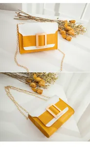 Détail du sac bandoulière bicolore avec boucle dorée et bandoulière chaîne