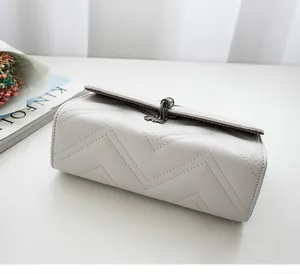 Detailed close-up of quilted V-pattern leather handbag with elegant tassel charm