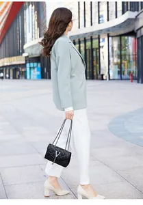 Sac carré noir matelassé avec logo V argenté et pompon porté en bandoulière