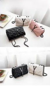 Détail d'un sac à chaîne matelassé avec boucle en V en métal et pompon à franges chic