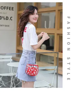 Détail du sac transparent rouge aux marguerites avec bandoulière chaîne dorée