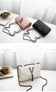 Détail de sacs à chaîne matelassés avec gland et logo V en métal en rose, noir et blanc