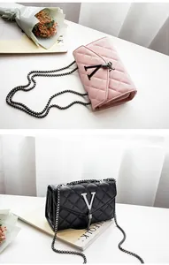 Détail de sacs bandoulière matelassés avec logo V en métal et pompon à chaîne