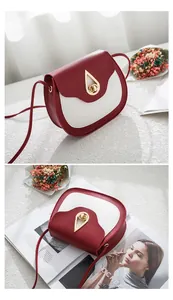 Detail of red and cream saddle bag featuring a gold water-drop rotating metal lock