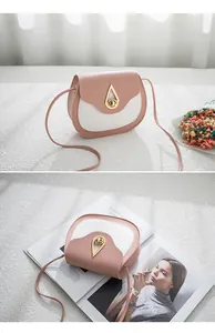 Detail view of pink and white saddle bag featuring a golden water drop twist lock