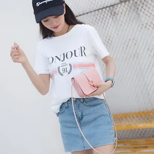 Petit sac à bandoulière rose minimaliste avec boucle dorée porté par un mannequin
