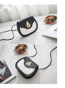 Detail of small saddle bag with black and white color blocking and gold water drop lock