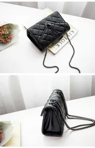 Gros plan d'un sac à chaîne noir matelassé avec boucle en V et texture de cuir