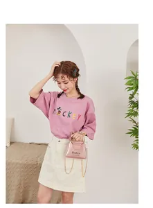 Pink transparent tote bag featuring gold cat-ear metal handles and elegant printed text