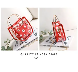 Détail du sac transparent en PVC à motif marguerites avec anneau doré et chaînette