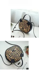 Detail of round leopard print cat crossbody bag featuring gold whiskers and black ears