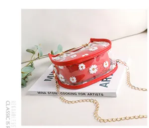 Détail du sac transparent en PVC avec bordure rouge et pochette intérieure marguerite