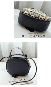 Detail showing leopard print fabric and golden metallic cat whiskers on round crossbody bag