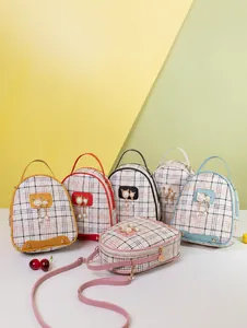 Detail showing colorful plaid textured mini handbags with pearl and cat-shaped pendants