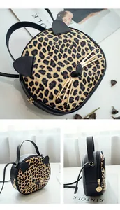 Detail view of round leopard print crossbody bag with cat ears and gold hardware