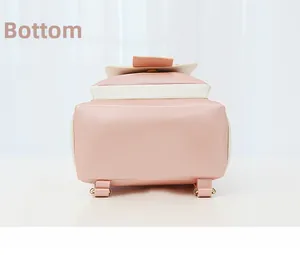 Detail view showing precise stitching and golden metal hardware on pink leather bag bottom