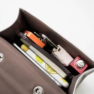 Internal view of minimalist shoulder bag with multi-layer compartments and zip pocket