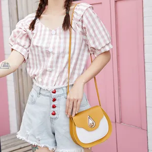 Chic two-tone saddle bag in ginger yellow and off-white leather with a teardrop lock