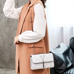White V-quilted shoulder bag with metal chain strap and decorative tassel charm