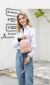 Vista de estilo de vida de una mini mochila rosa con estampados Lucky Girl en una modelo