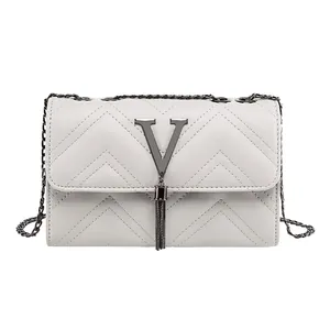 White faux leather chain crossbody bag with V-shaped metal logo and long tassel detail