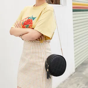 Black round PU leather crossbody bag with quilted pattern, tassel detail, and chain strap