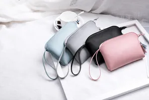 Dettaglio di quattro mini pochette colorate con cinturino e nappe in un set elegante